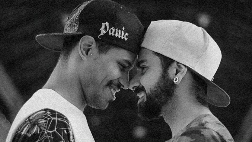 Imagem de um casal homossexual de frente um para o outro sorrindo e com suas testas coladas representando os direitos LGBT+ no Brasil