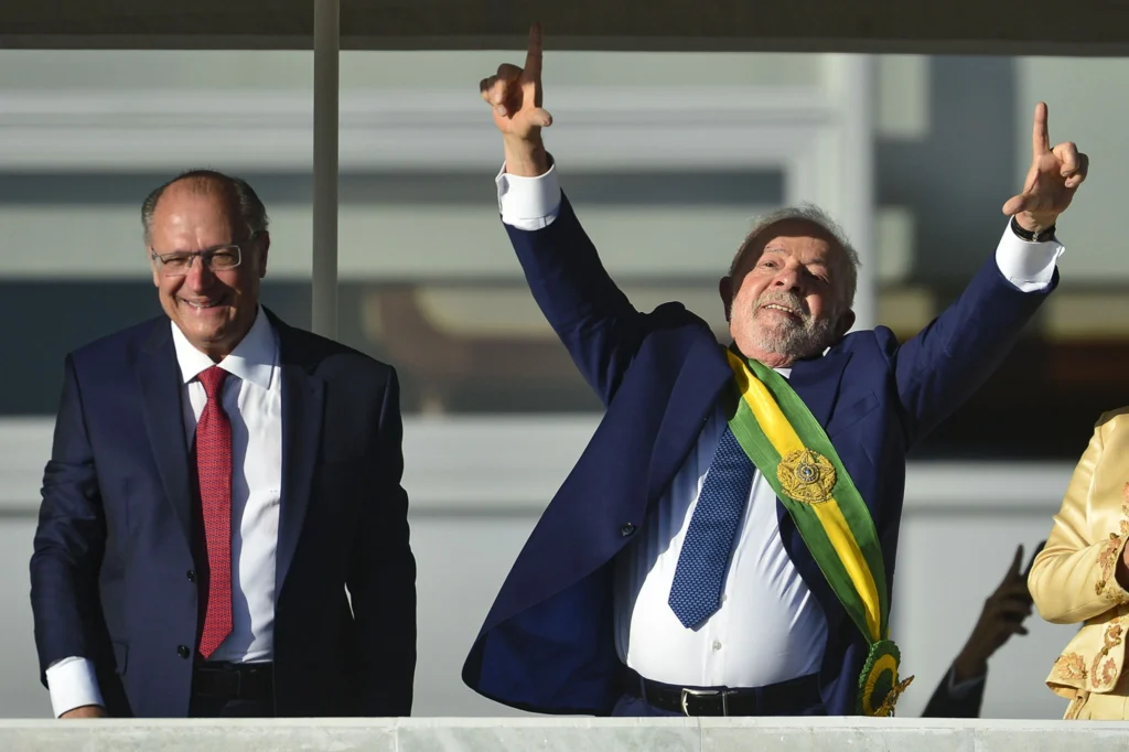 Os cargos de Presidente e Vice-Presidente só podem ser exercidos por brasileiros(as) natos(as). Dois homens brancos em carro oficial do governo, em pé, durante a posse presidencial