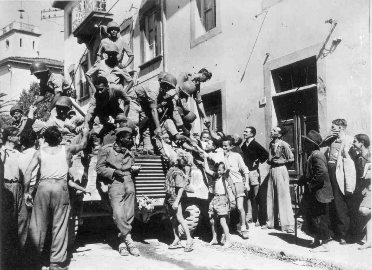 Soldados da Força Expedicionária Brasileira (FEB) sendo saudados por moradores de Massarosa, na Itália, no final de setembro de 1944. Texto: Segunda Guerra Mundial: como impactou a história?