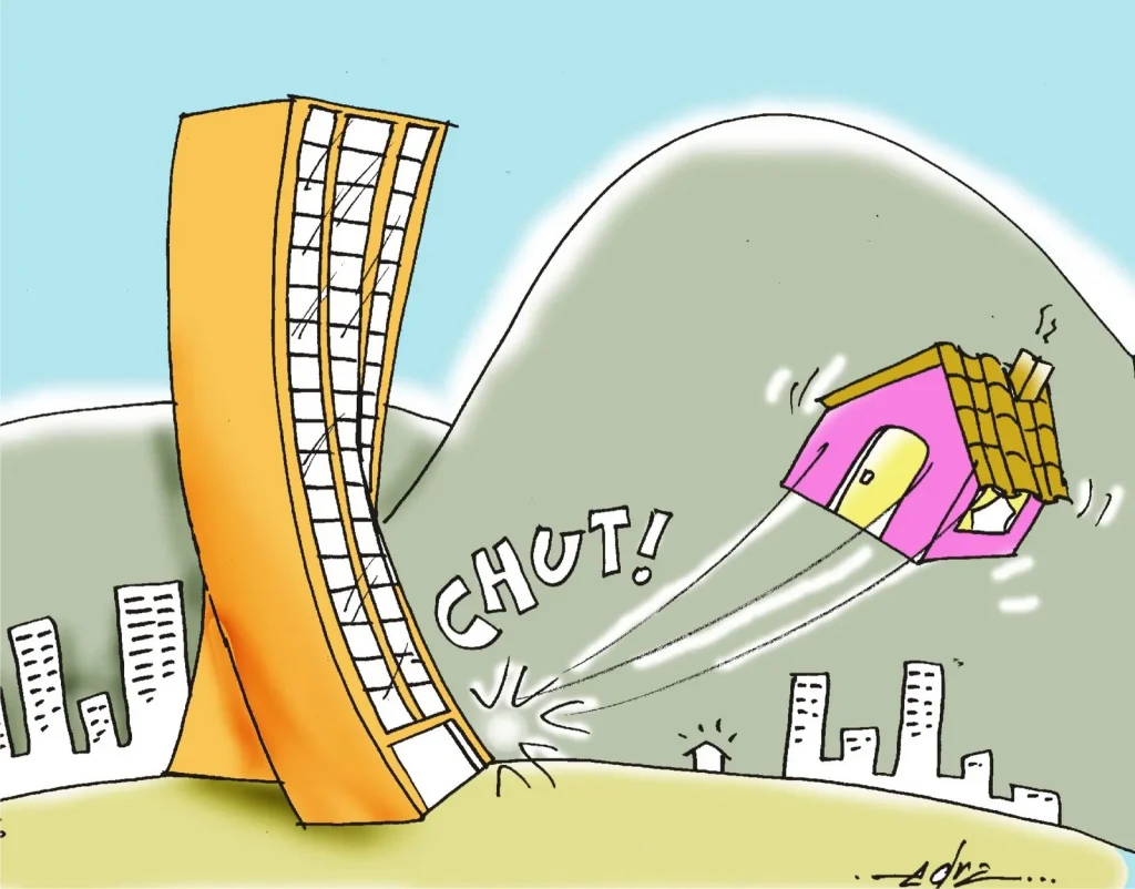 A imagem é uma charge que retrata um prédio alto e moderno chutando uma pequena casa, que está sendo arremessada para longe. O prédio está inclinado como se tivesse dado um chute na casa, e há uma onomatopeia "CHUT!" próxima ao ponto de contato. A casa é simples e parece estar em uma área rural, enquanto o prédio está em um ambiente urbano, com outros edifícios ao fundo. A imagem parece criticar o impacto da urbanização ou da especulação imobiliária sobre áreas residenciais mais simples, refletindo sobre a gentrificação