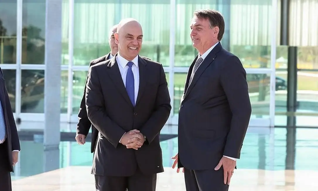 Alexandre de Moraes e Jair Bolsonaro aparentam estar confortáveis, rindo, durante encontro em 2022.