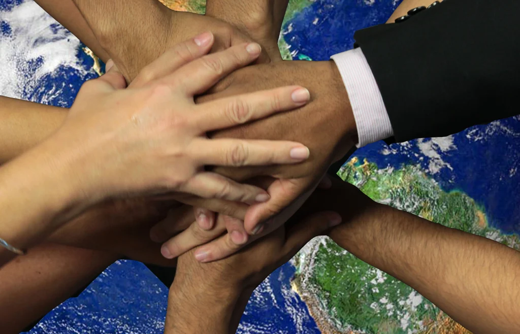 Várias mãos unidas sobre a imagem do planeta Terra, representando união, diversidade e a atuação do Ministério Público na defesa dos interesses da sociedade.