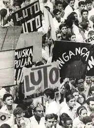 Manifestantes, segurando cartazes com dizeres como "luto", protestam contra a morte de Edson Luís.