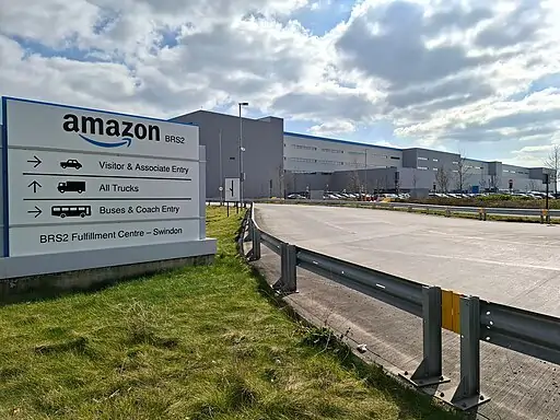 Placa com logo da Amazon em frente a um prédio.