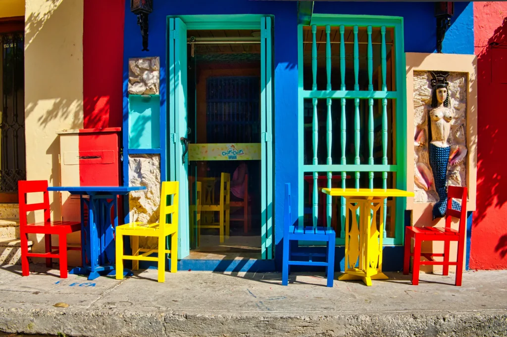 Foto de cadeiras coloridas em uma calçada, símbolo de latinidade.